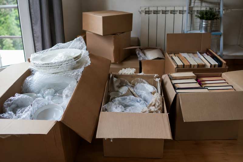 Cartons de vaisselle et de livres triés avant enlèvement