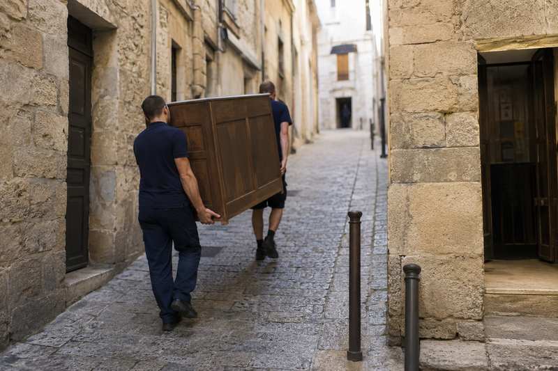 Ruelle de centre ancien, portage d'un meuble