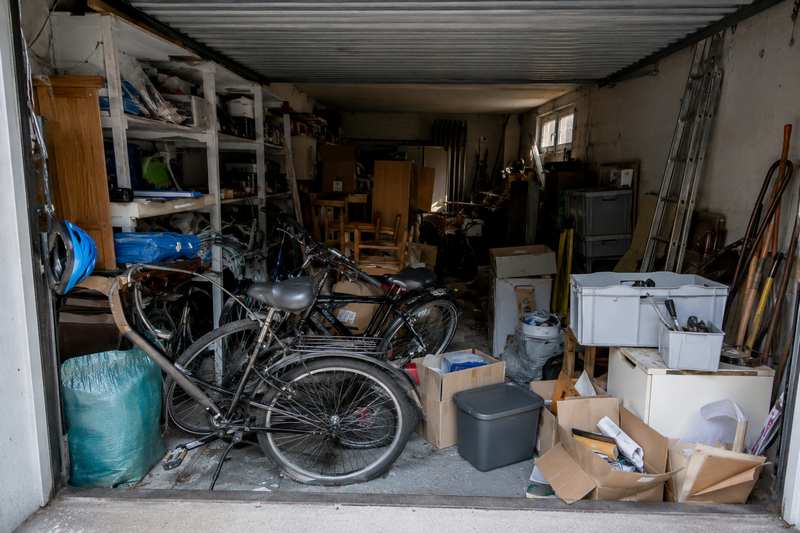 Garage rempli de vélos, cartons et outils avant débarras