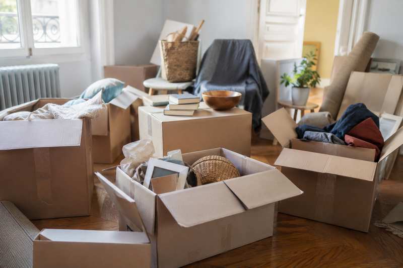 Pièce de maison en cours de tri avec cartons ouverts